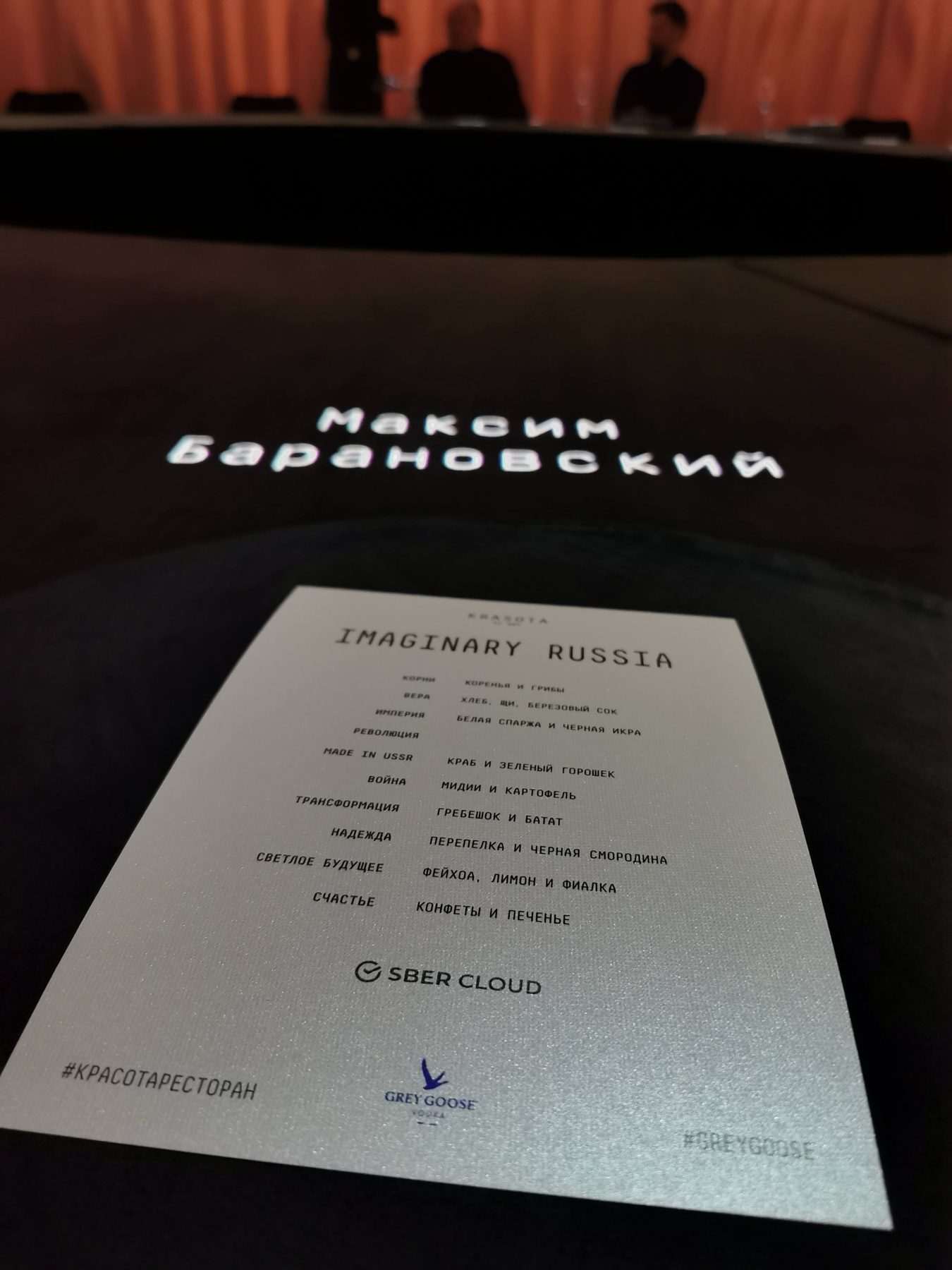 Меню на тёмном столе и проекция имени гостя