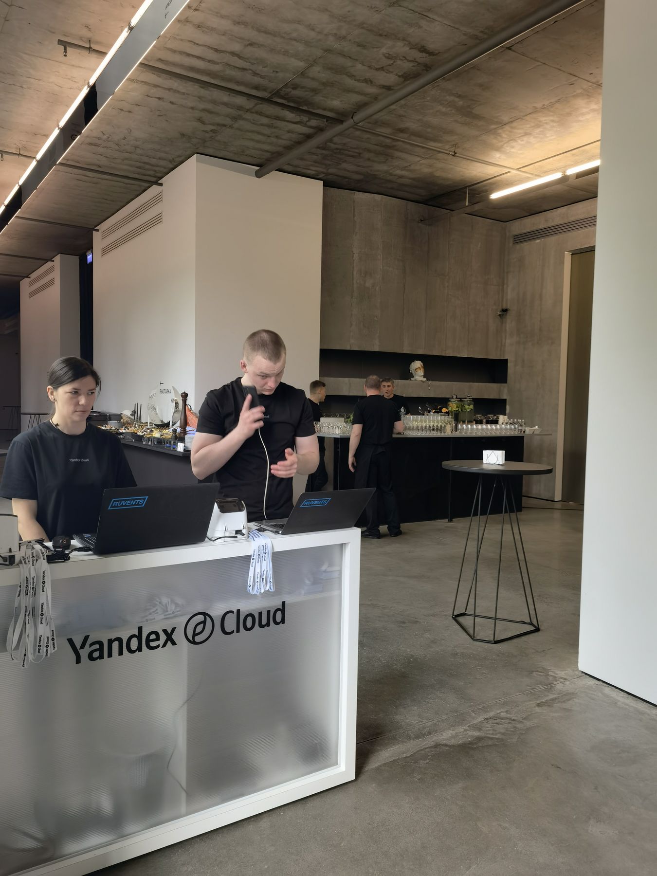 Стойка регистрации Yandex Cloud с бейджами и лентами, за ней бар, 19.05.2022